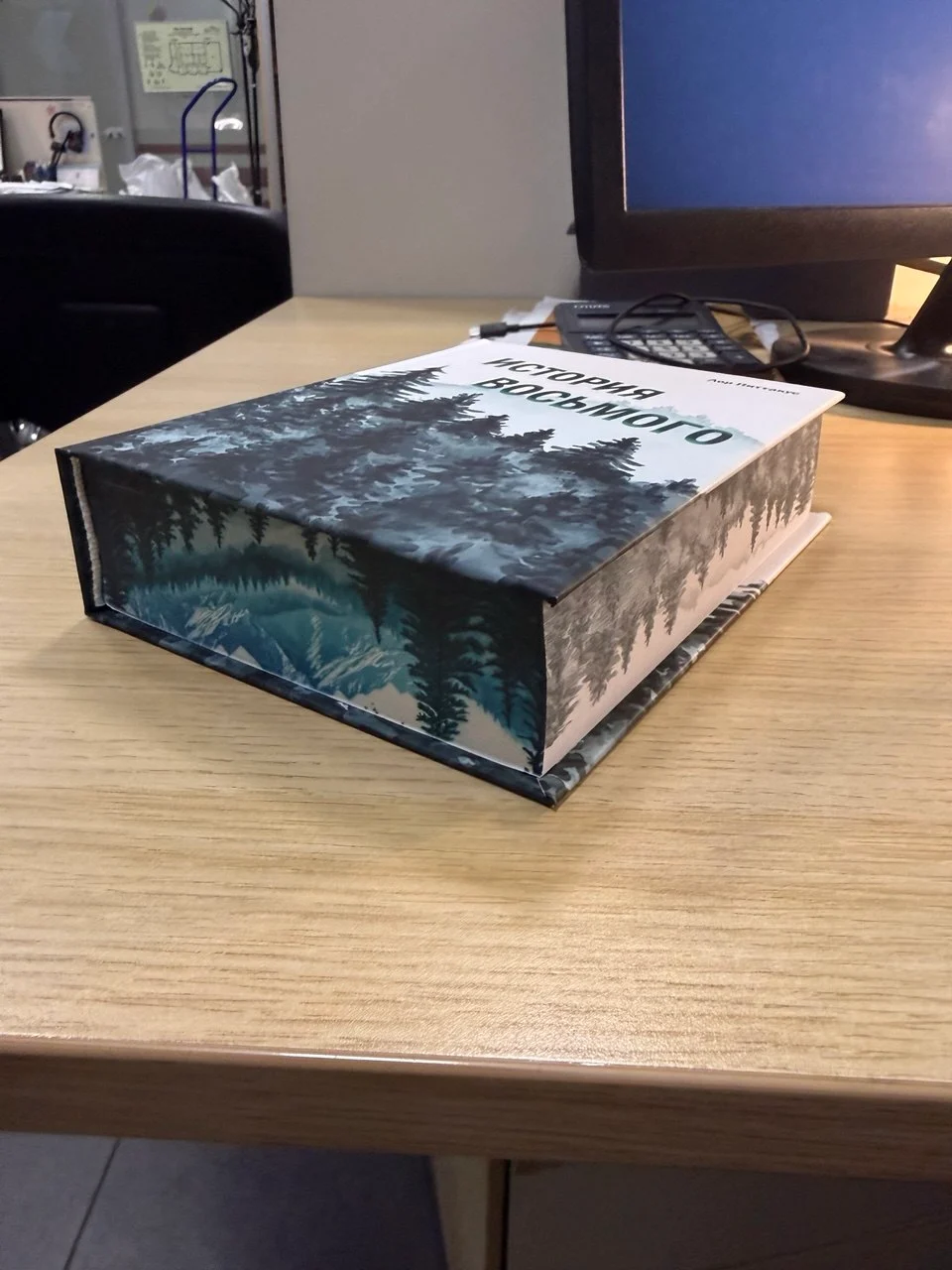 Книга «История восьмого» с лесным пейзажем на обложке и обрезе